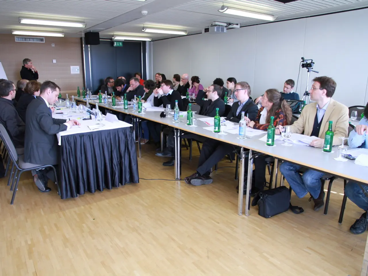 The picture is an office space. In the picture there are lot employees seated in the chairs in...