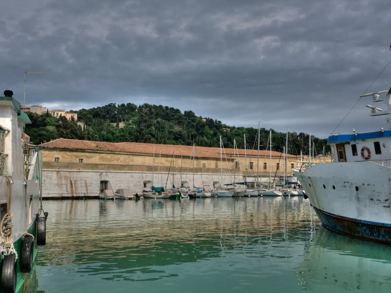 In the picture I can see many boats are floating on the water. In the background, I can see the...