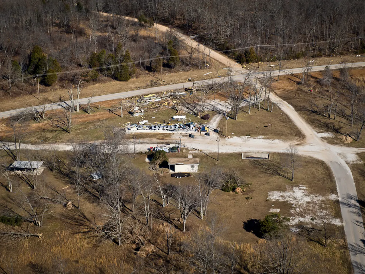 This image consists of many trees. At the bottom, there is ground. And there are small houses. At...