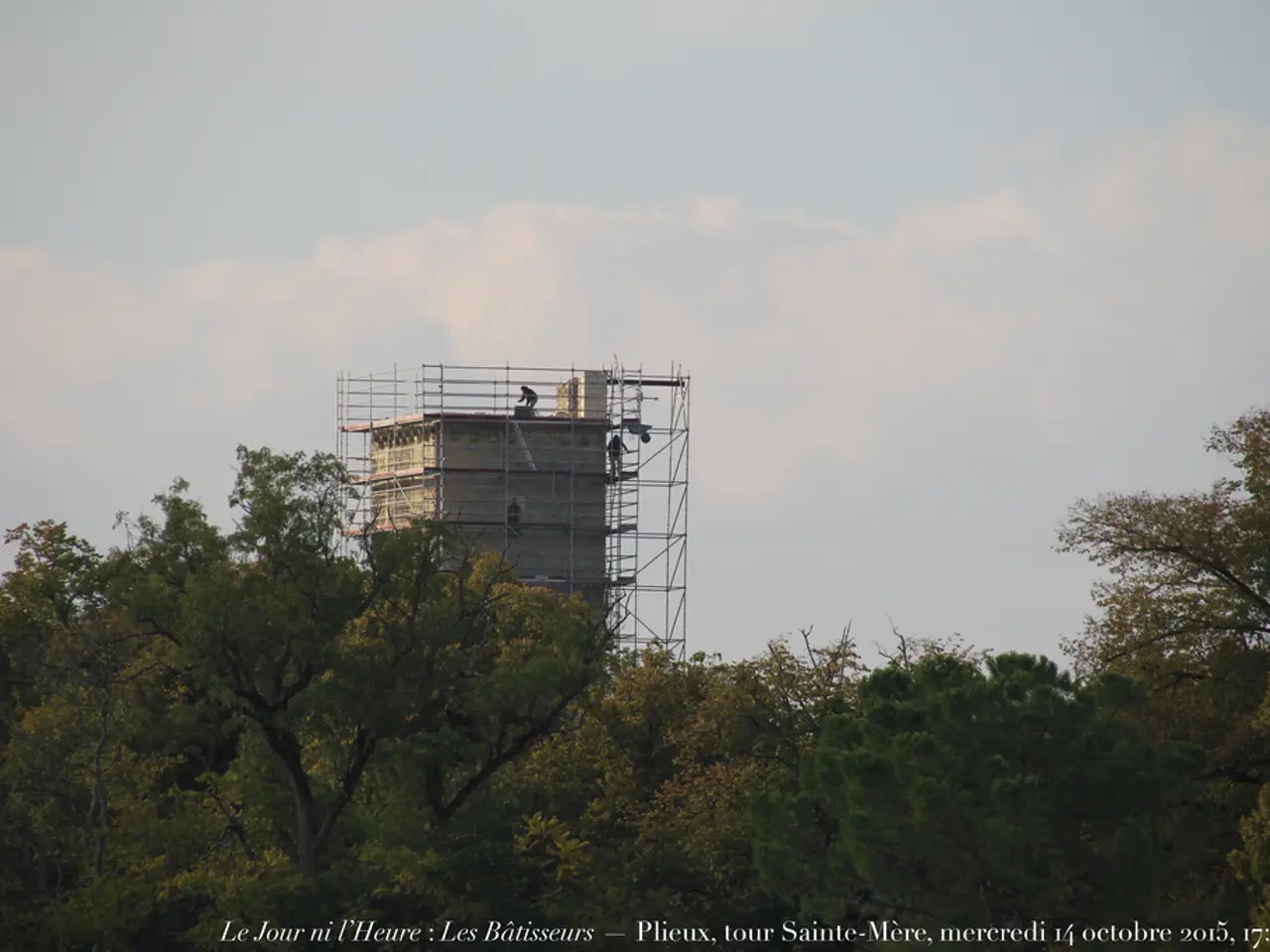 In this image there are some trees in the bottom of this image and there is one construction...