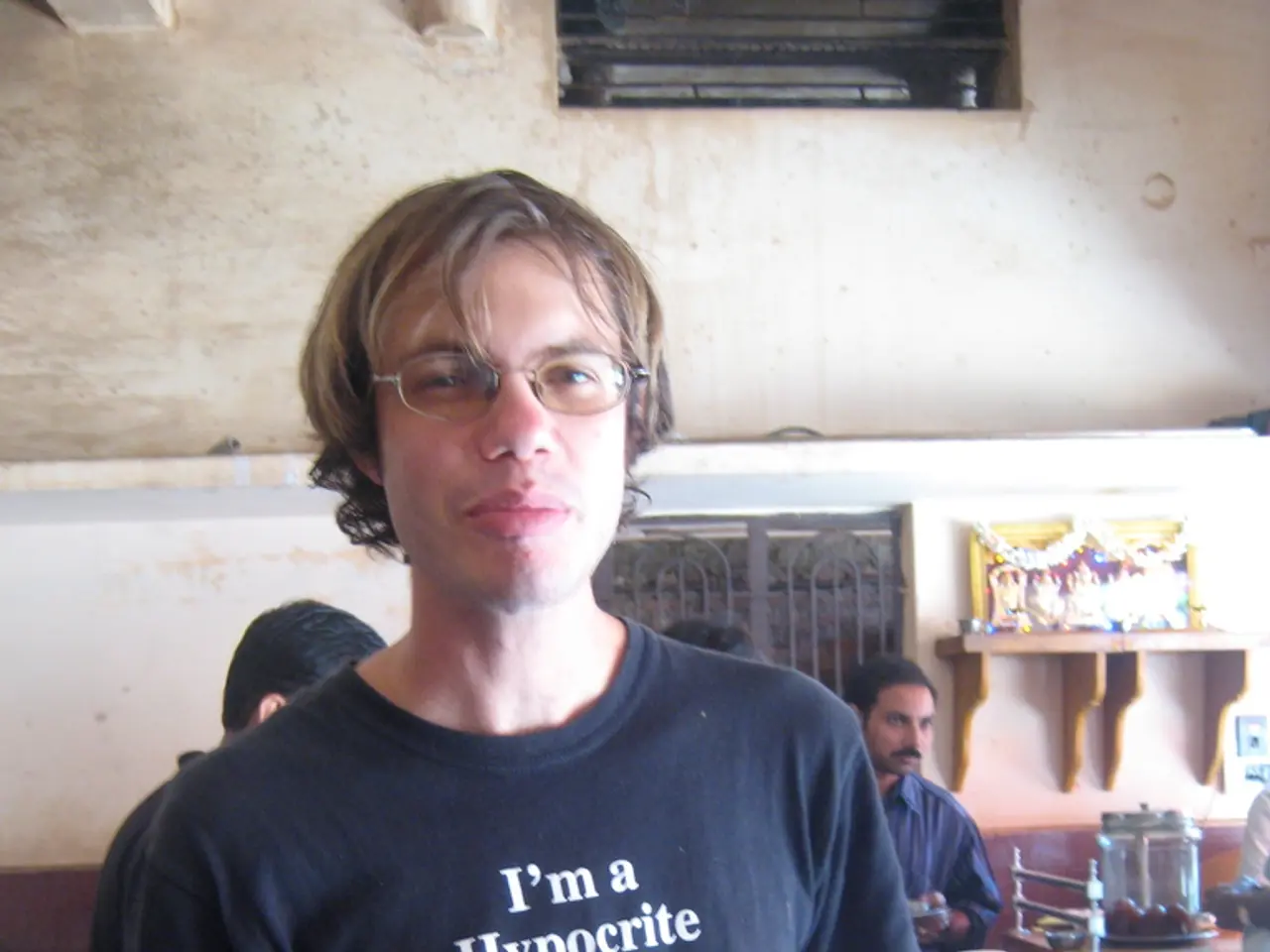 It is a hotel , a person is having food there is also a bottle on the table he is holding food in...