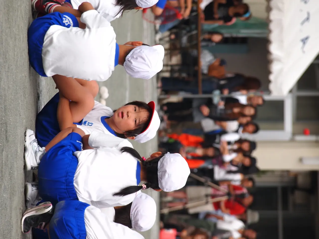 In the foreground of this image, there are kids sitting on the road. In the background, there are...