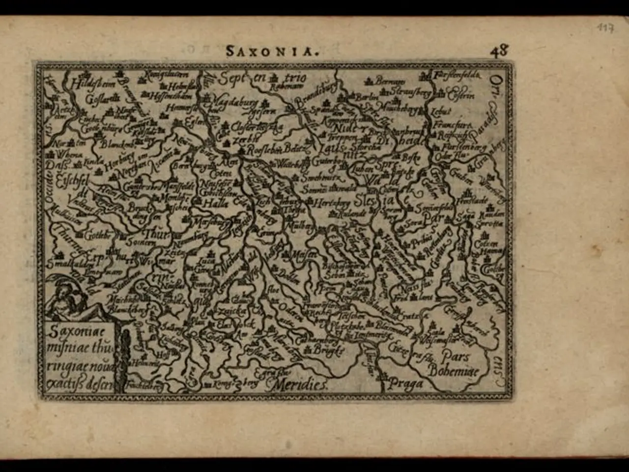 The image shows an old book with a map of Saxonia on it, set against a black background. The map is...