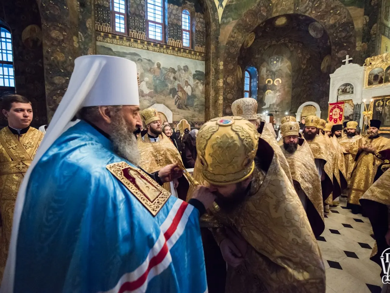 The image shows a group of people standing in a church, with some wearing caps. In the background,...