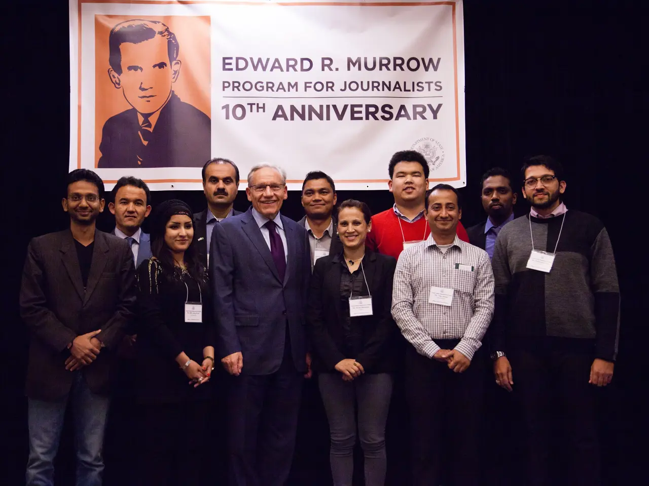The image shows a group of people standing in front of a banner that reads "Edward R. Murrow...