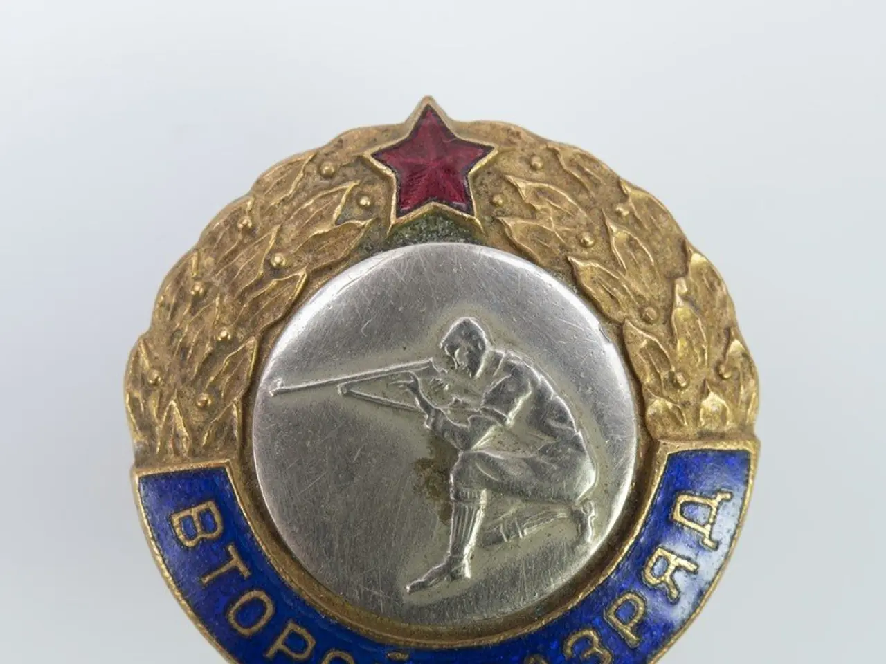 The image shows a Russian military badge with a red star on it. The badge is in the center of the...