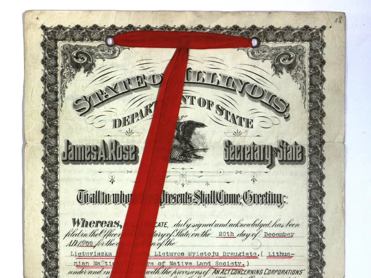 The image shows a certificate with a red ribbon tied around it and a gold seal on top. The...