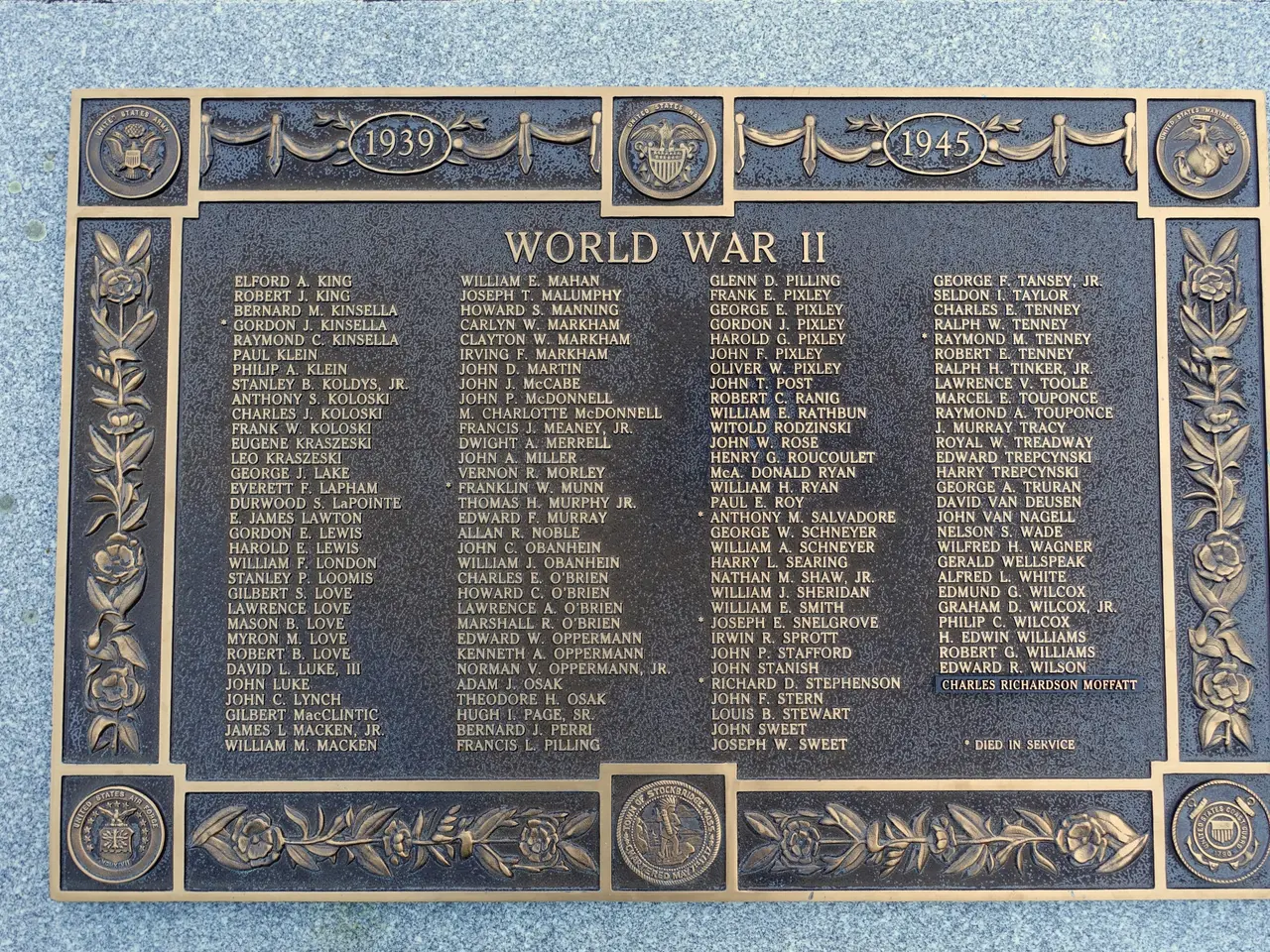 The image shows a plaque on the side of a building that reads "World War II". The plaque is made of...