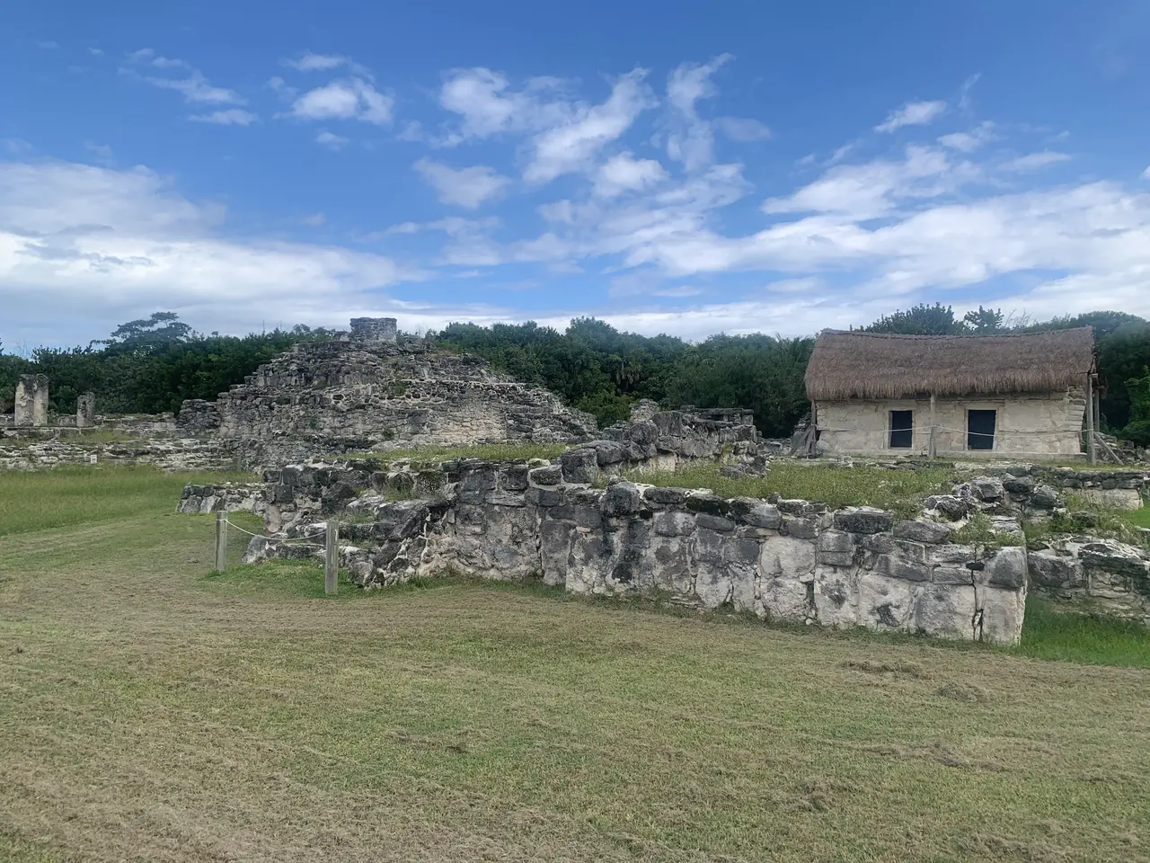 The image shows the ruins of the Mayan city of Tikalpa, Guatemala, with a grassy land in the...