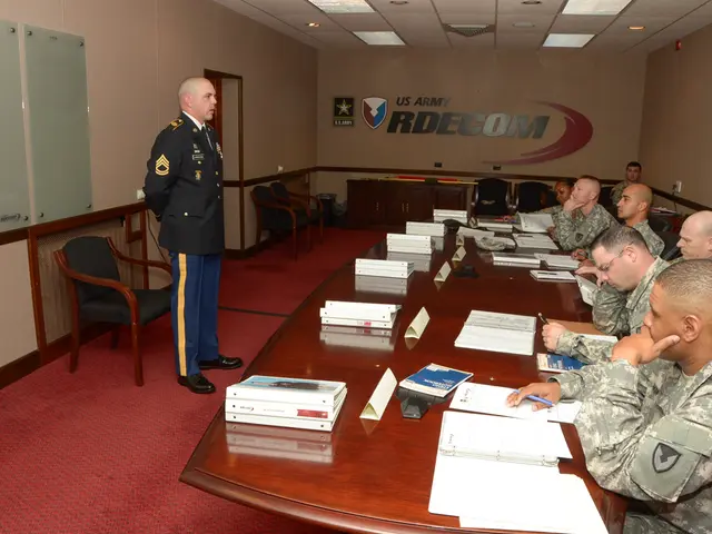 on the desk the papers and the files are kept. on the right side people are sitting in a uniform...