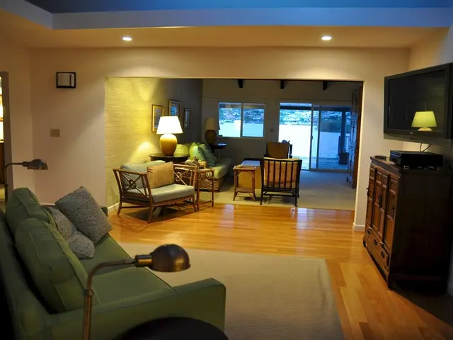 In this picture there is a couch with two pillows and as a television on the night