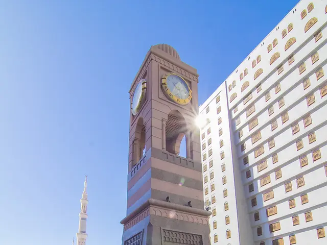 In the middle it is a structure which has clock in it. In the right side it is a very big building.