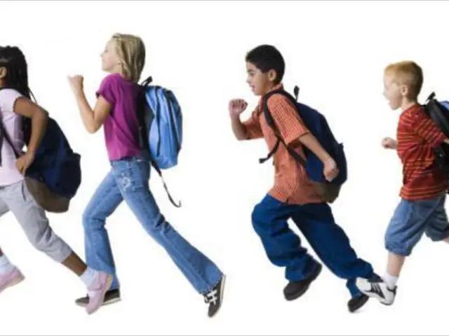 In this image there are kids running wearing bags.