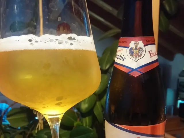 In this image there is a wine bottle and also a glass of wine placed on the wooden surface. In the...