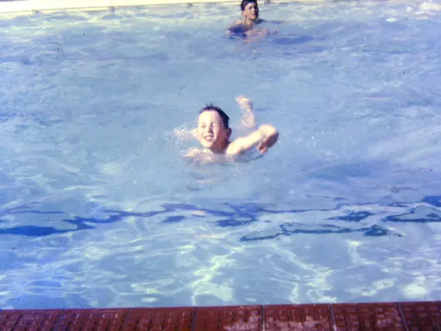 Here in this picture we can see a couple of children swimming in the pool, which is full of water...