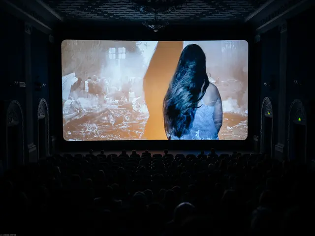 In this picture I can observe screen in the middle of the picture. It is looking like theater. The...