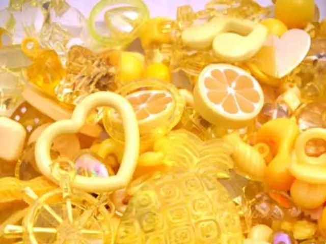 There is a button, symbols and other toy items and rings arranged on a white color sheet. And the...