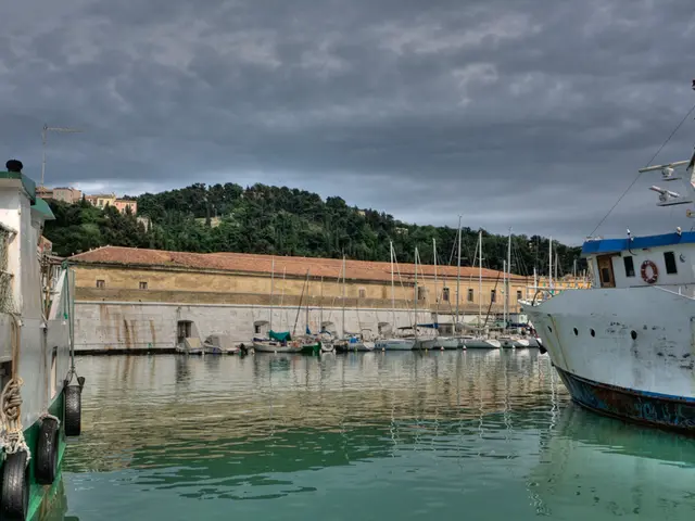 In the picture I can see many boats are floating on the water. In the background, I can see the...