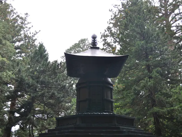 In the center of the image there is a black color memorial. In the background of the image there...