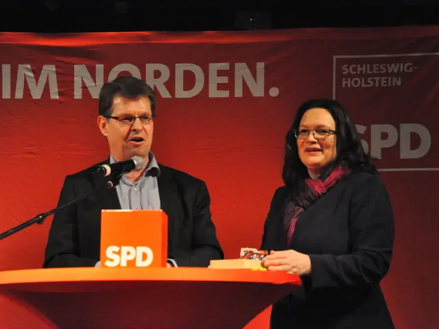 In this image we can see there are two people smiling and standing on the stage, in front of them...