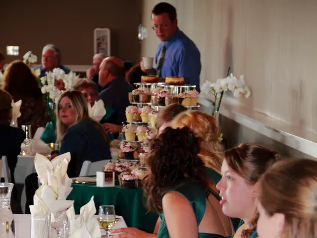 This image is clicked in a restaurant. There are many people sitting on the chair. In front of the...