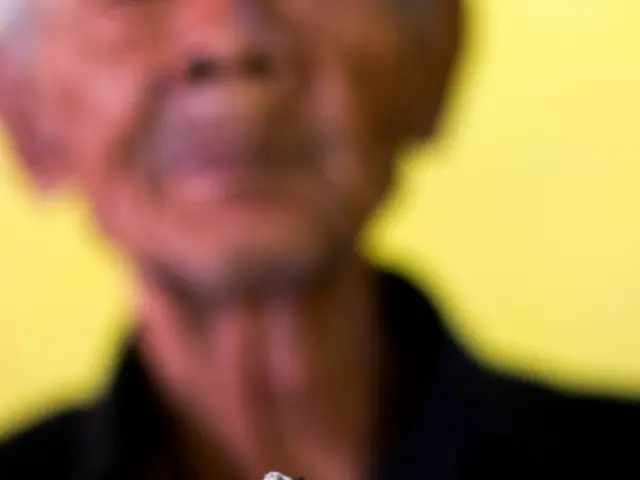 In this image we can see a person holding a cigarette in his hand.