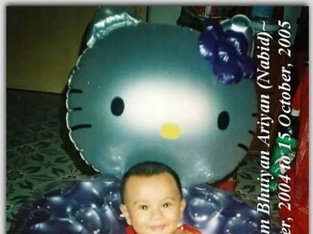 In this picture we can see a child smiling and sitting on a balloon chair, some text and in the...