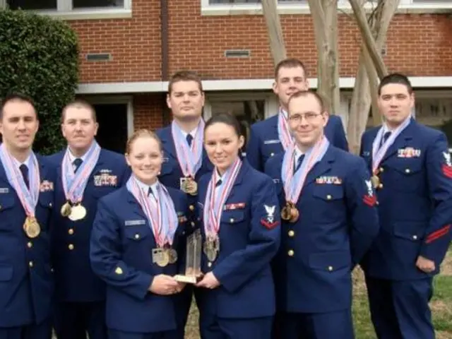There are persons in violet color dresses, wearing medals, smiling and standing. Two of them are...