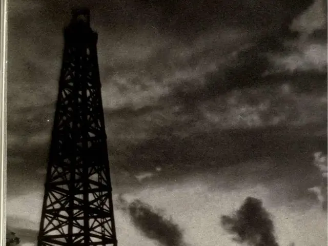 The image shows a black and white photo of oil fields in Montebello, California, with tall towers...