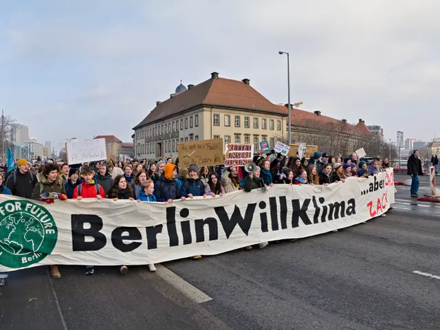 The image shows a group of people walking down a street, holding a banner with the words "Berlin...