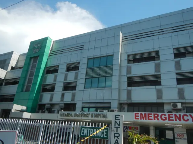 The image shows a large building with a sign that reads "Emergency" in front of it, surrounded by a...