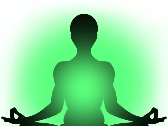 The image shows a silhouette of a person sitting in a lotus position on a green and white...