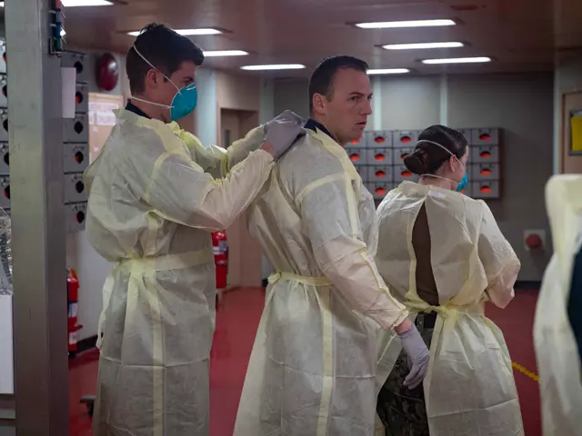 The image shows a group of people in protective gear standing next to each other in a room with a...