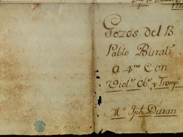The image shows an old book with handwriting on it, set against a dark background. The text on the...