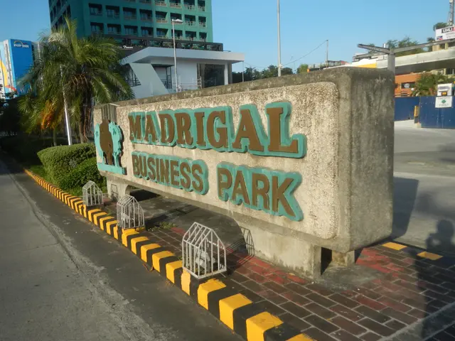 The image shows the entrance to Madrigal Business Park, with a name board on the wall, a metal...