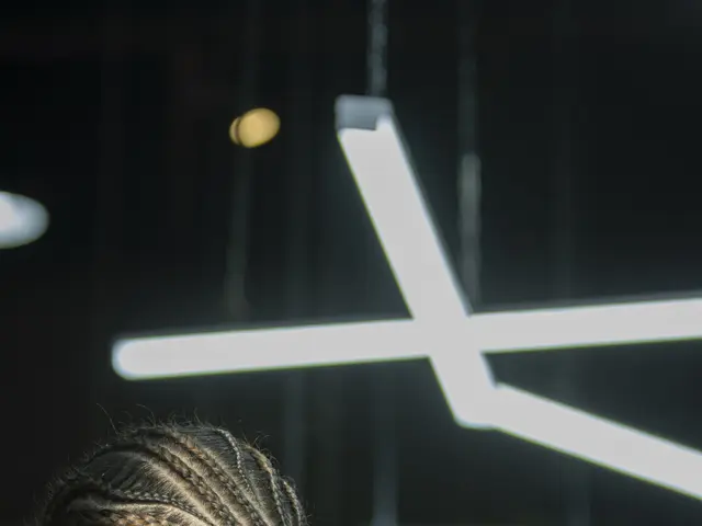 The image shows a man getting his hair cut at a barber shop. He is wearing a black t-shirt and is...