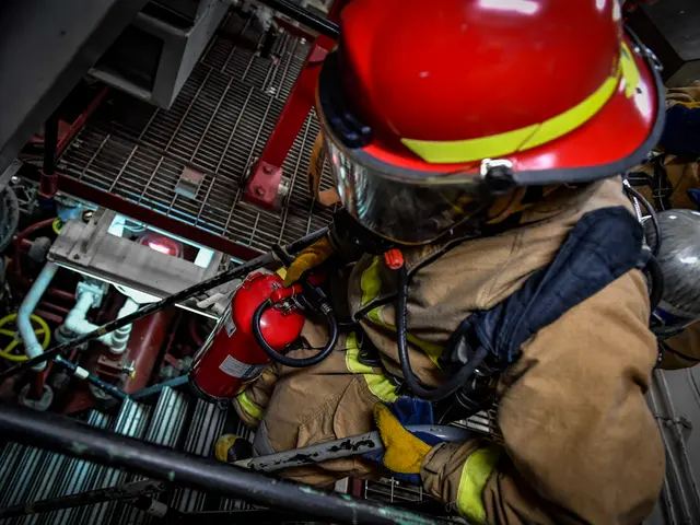 The image shows a firefighter wearing a helmet and gloves, holding a fire extinguisher in one hand...