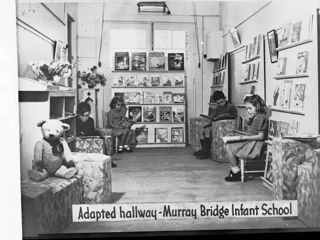 The image shows a group of children sitting in chairs in a room with bookshelves filled with books,...