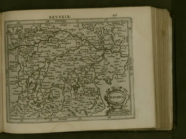 The image shows an open book with a map of Bavaria on it. The map is detailed and shows the various...