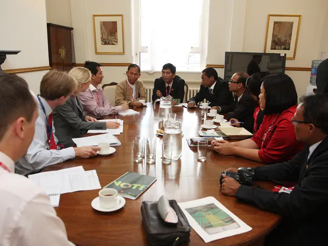 In this picture we have a conference like round table, here we can see some people sitting around a...