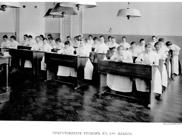 The image shows a black and white photo of a classroom full of children sitting at desks, with...