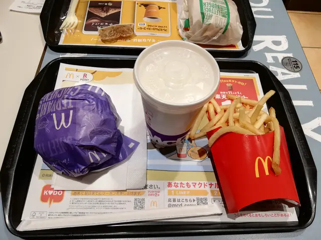 The image shows a table with a tray on top of it, containing a McDonald's meal consisting of french...