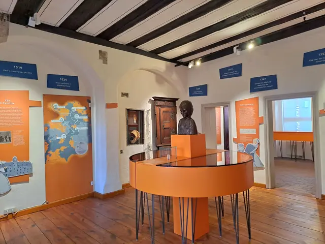 The image shows a room with a wooden floor, a table with a statue on top of it, a wall with a door,...