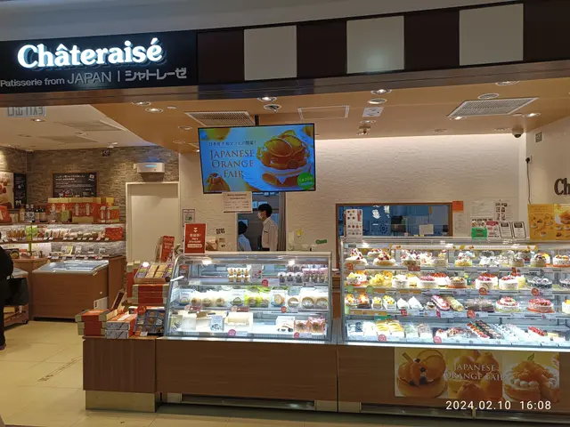 The image shows a chateraise bakery in Japan, with a display case filled with a variety of cakes...