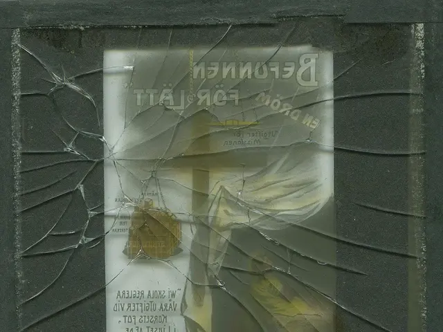 The image shows a broken glass window with a piece of paper attached to it. The paper has text...
