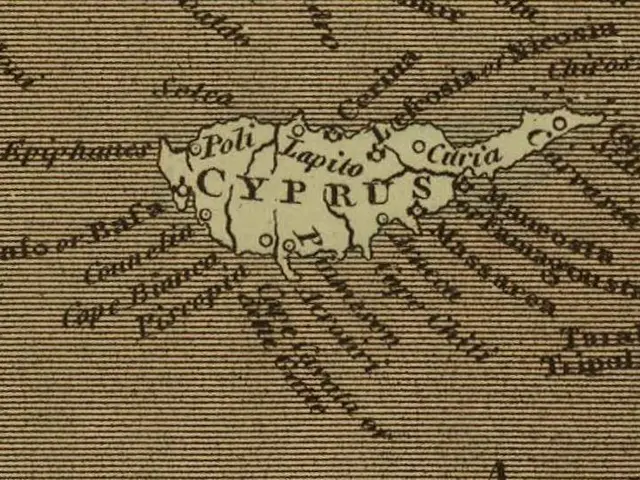 The image shows an old map of Cyprus on a piece of paper with text written on it. The map is...
