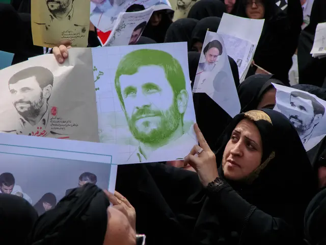 The image shows a group of Iranian women holding up pictures of Iranian President Mahmoud...
