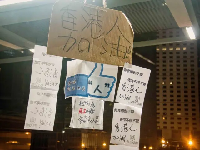 The image shows a group of people standing in front of a building at night, illuminated by the...