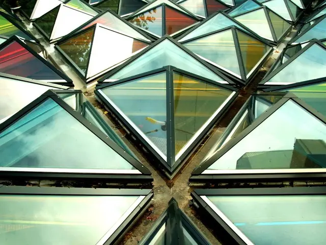 The image shows a building with many glass windows, each with a unique design. The windows are...