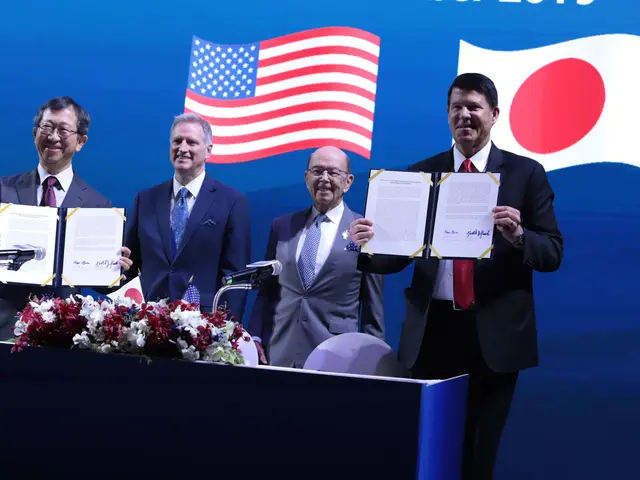 The image shows a group of four men standing next to each other at a podium, each holding a book in...